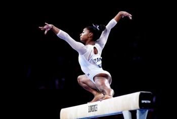 Simone Biles performing on the balance beam for Team USA