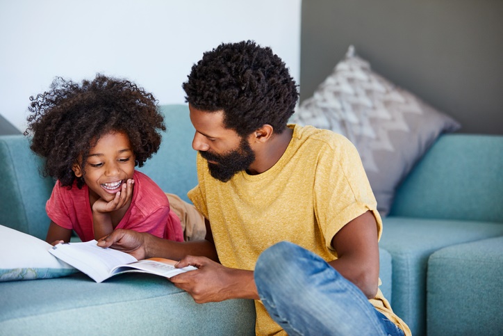 Dad reading with his tween daughter