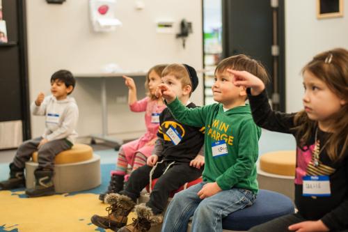 Kids pointing while being read a story