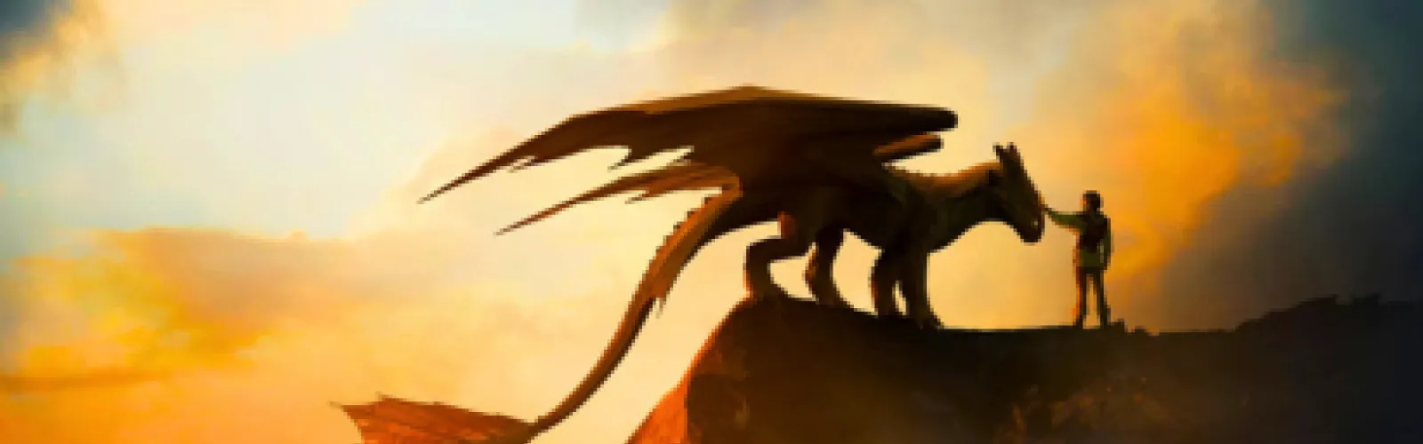 A sunset with dragon and man in the foreground standing on top of a hill.