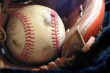 A dirty baseball sitting in a baseball mitt