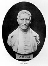 A bust of Louis Braille made out of stone against a black background