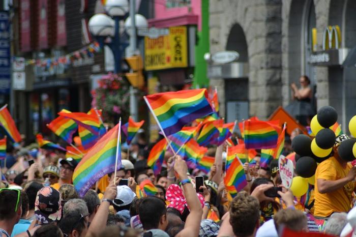 Huge group of people waving rainbow flags in the street