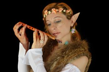 Photo of a woman in an elf costume playing a woodenflute